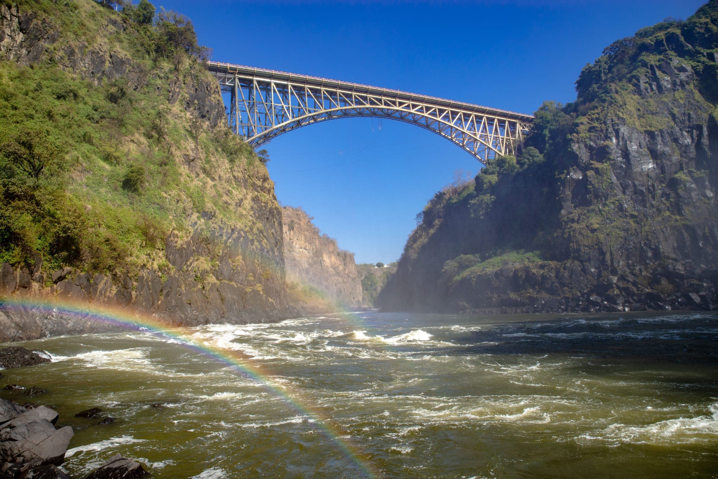 The Victoria Falls Bridge spanning the gorge, with spray rising from the Falls